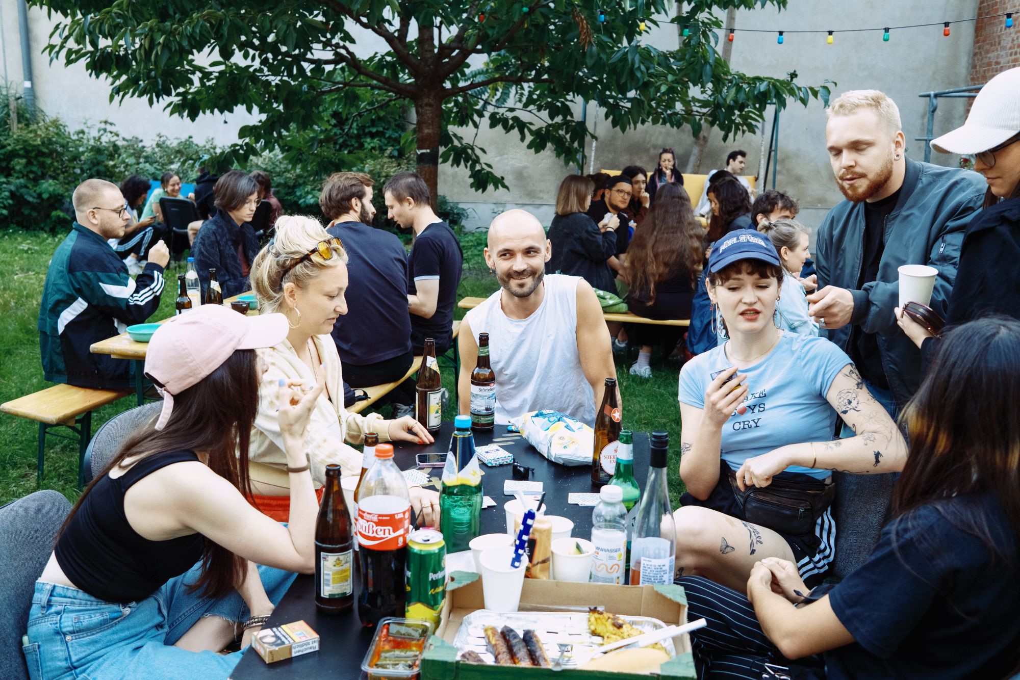 Menschen spielen Durak und sitzen an Bierbänken beim Durak-Sommerfest im Jugendclub Magda in Berlin-Lichtenberg (2025)